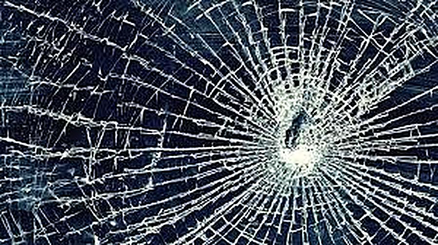 Cracked laptop screen with spiderweb fractures from physical impact
